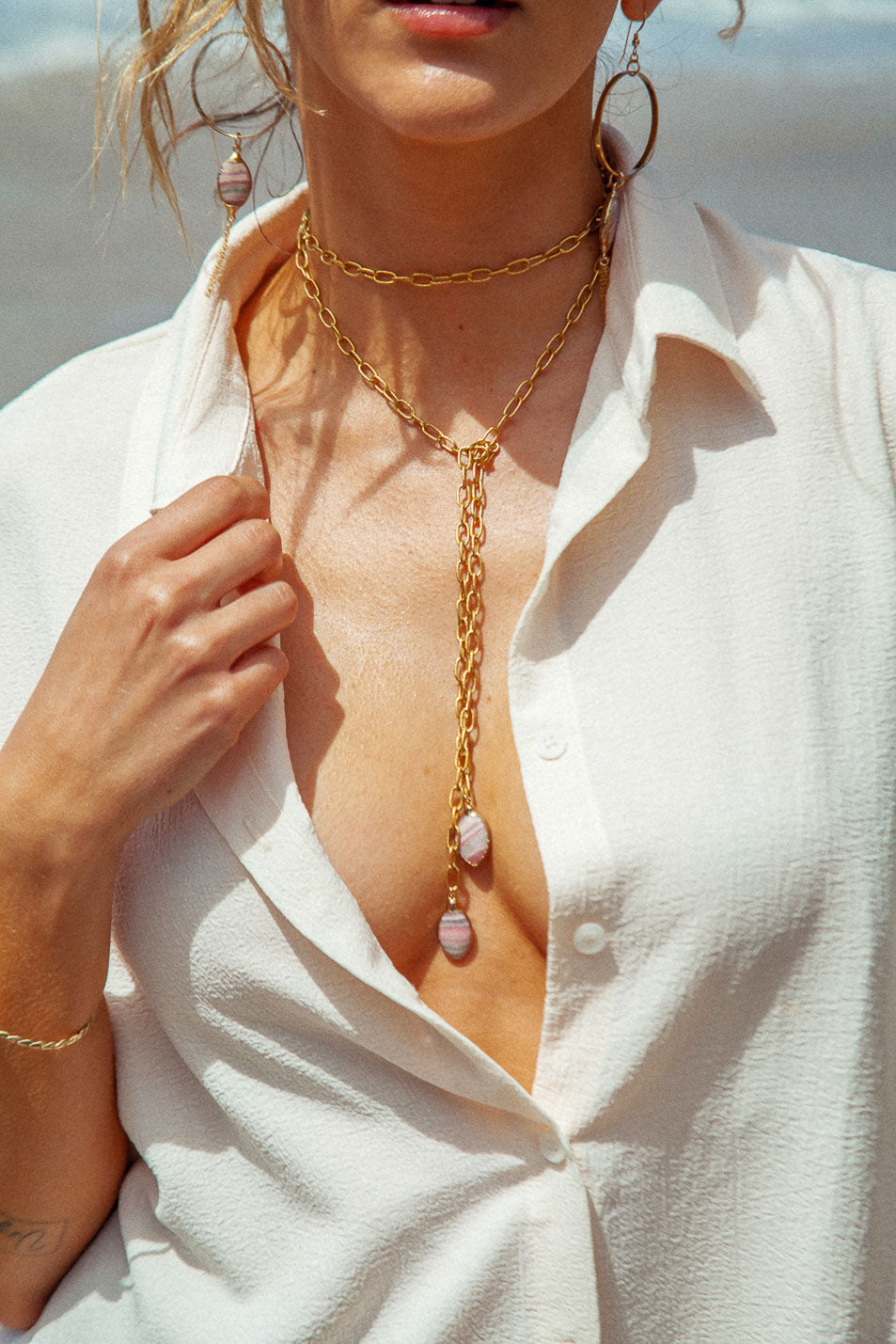 Elegant hoops with marquis-shaped Rhodochrosite stone and chain dangle. Expertly crafted for a glamorous touch. Earrings are 4" in length. Stones vary in coloration and pattern.